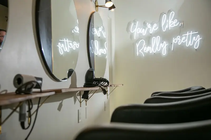 The salon floor lit by neon signage.