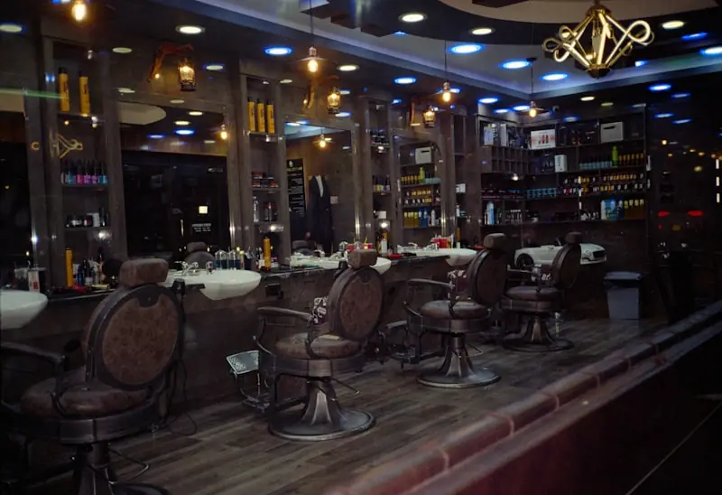 An empty barbering room with chairs and mirrors.