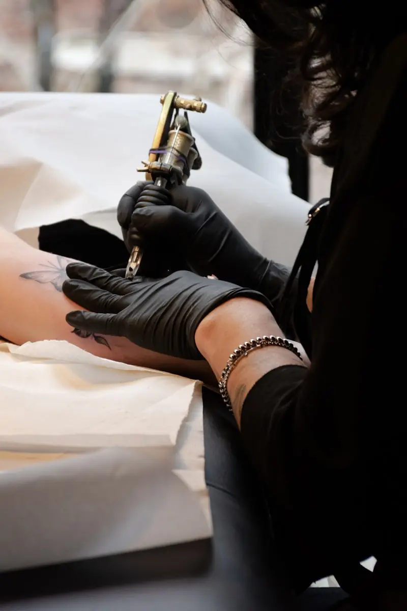 A tattoo machine held over a workstation.