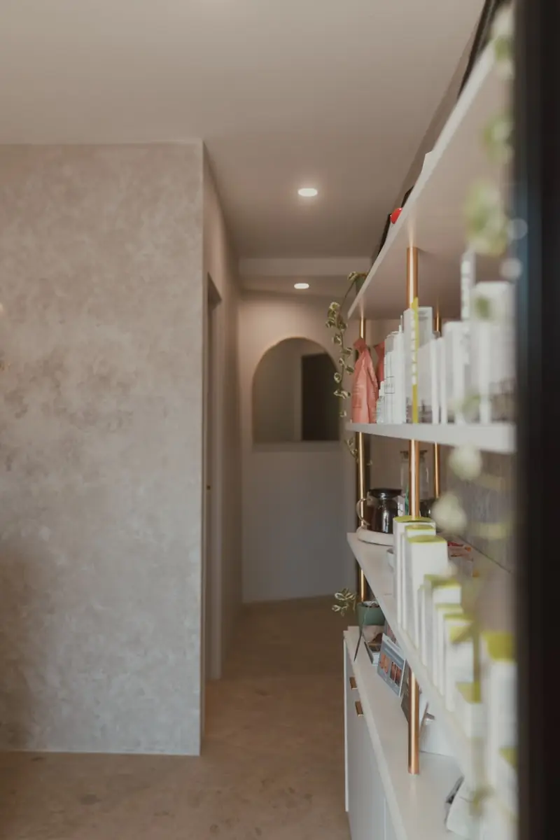Skincare products on shelves in a bright hallway.