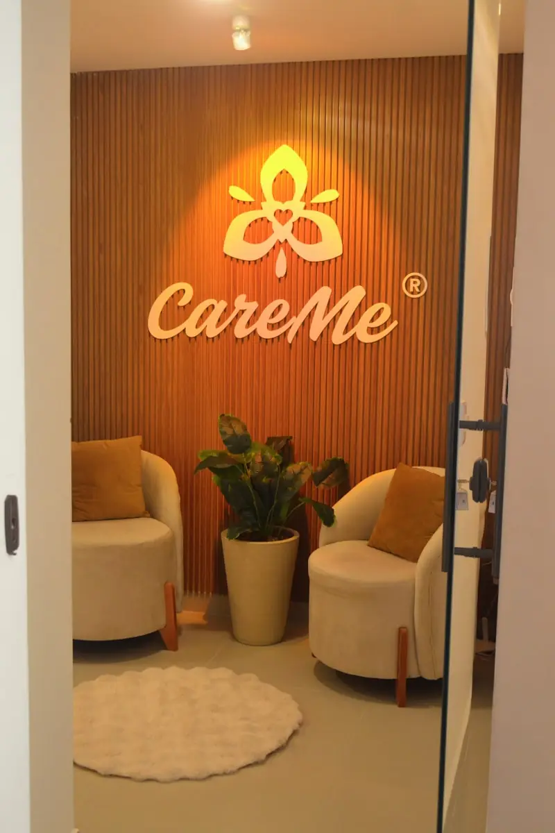Two cream armchairs either side of a potted plant.