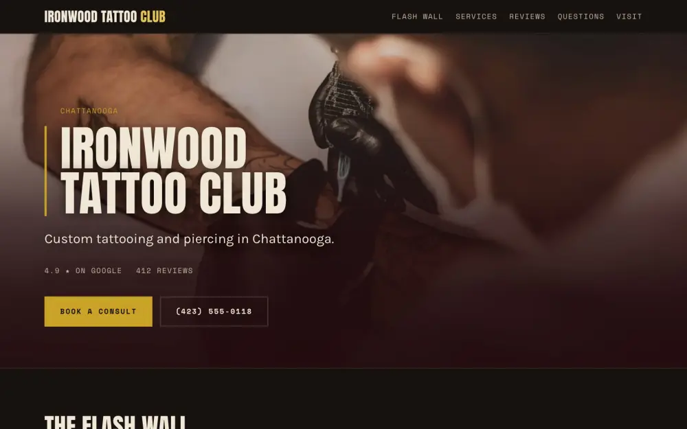 Home page of the Ironwood Tattoo Club demo site. An artist tattooing a forearm under a work lamp, shot close and shallow.